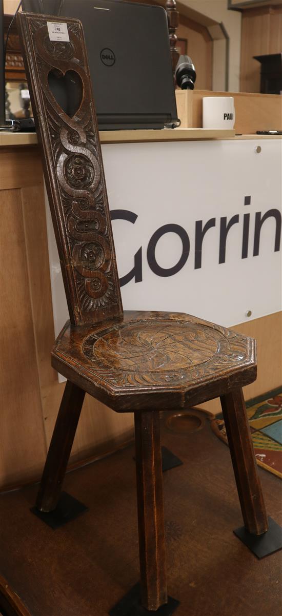 A carved oak milking stool, H.91cm